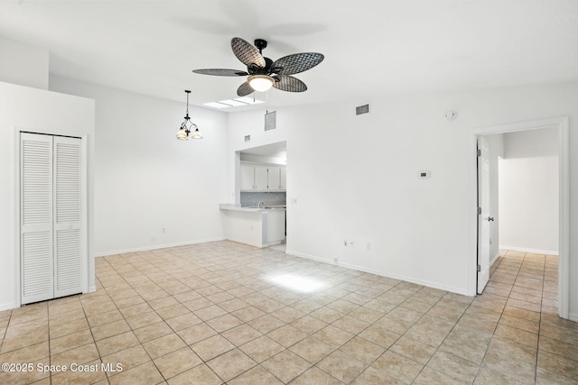 unfurnished living room featuring ceiling fan, visible vents, baseboards, and vaulted ceiling
