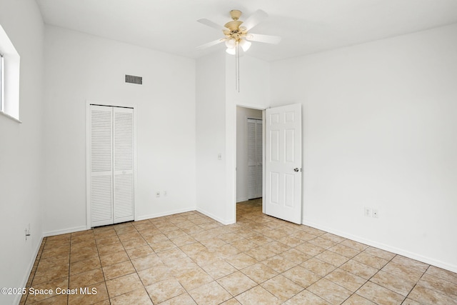 unfurnished bedroom featuring visible vents, a closet, baseboards, ceiling fan, and high vaulted ceiling