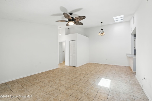 unfurnished living room with light tile patterned floors, baseboards, and ceiling fan with notable chandelier