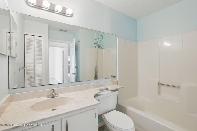 bathroom with vanity, toilet, visible vents, and a closet