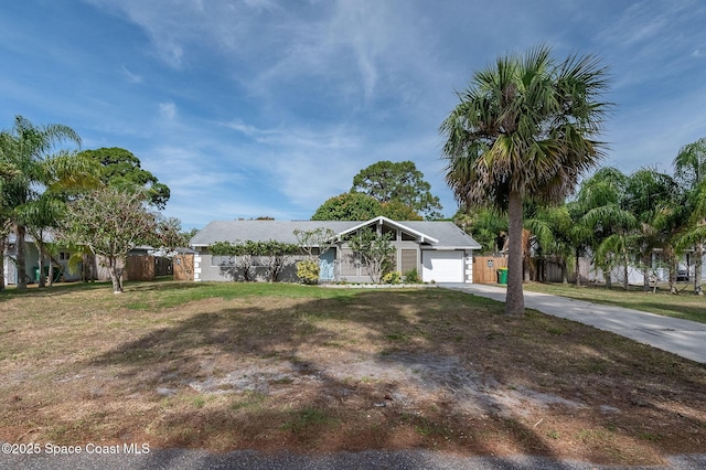 6010 Flamingo Ave, Cocoa, FL 32927 - ranch-style home with concrete driveway, an attached garage, fence, and a front lawn