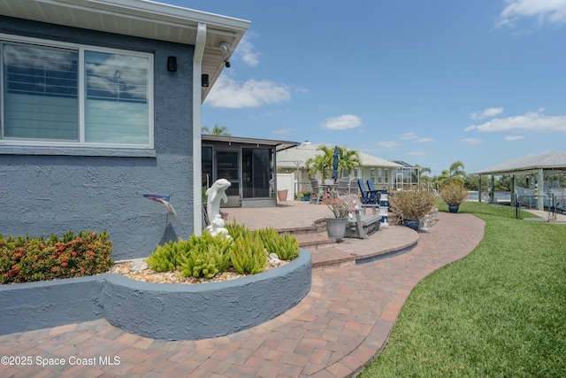 view of yard featuring a sunroom and a patio