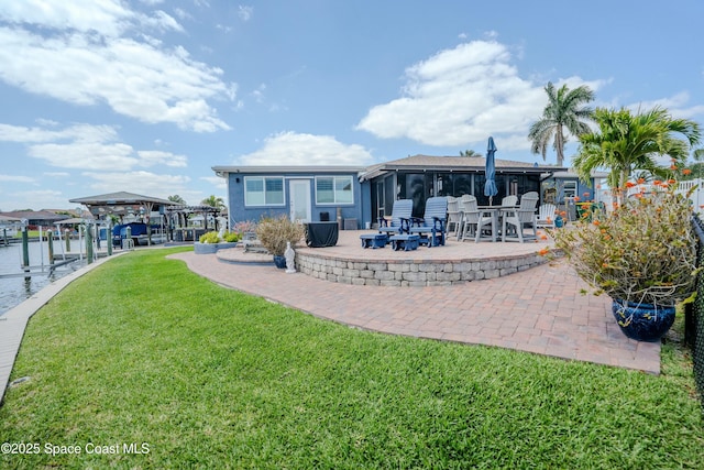 back of house with a patio area, a yard, and boat lift
