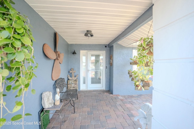 doorway to property featuring stucco siding and a patio