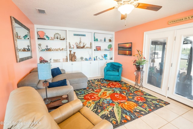 tiled living room with visible vents and a ceiling fan
