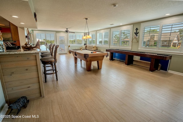 game room with a textured ceiling, a wealth of natural light, and billiards