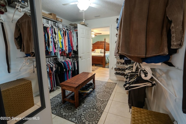 walk in closet featuring light tile patterned flooring, visible vents, and ceiling fan