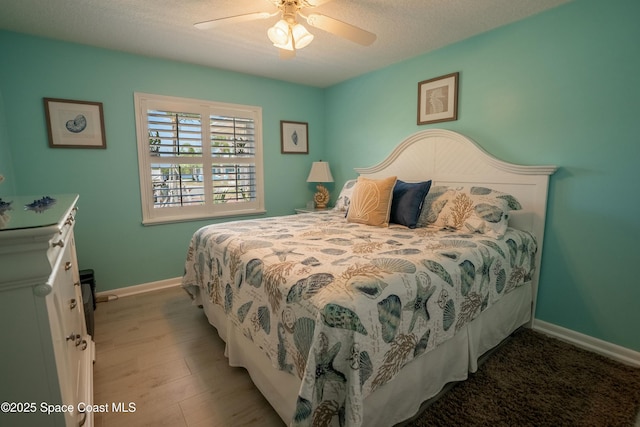 bedroom with wood finished floors, a ceiling fan, and baseboards