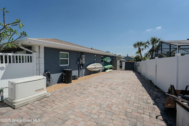 back of property with a fenced backyard, a gate, roof with shingles, and stucco siding