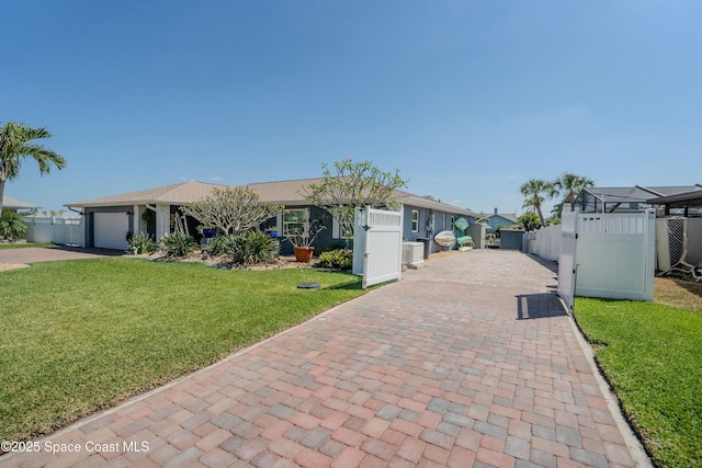 ranch-style house featuring a gate, fence, a front lawn, decorative driveway, and a garage