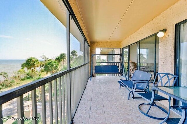 sunroom with plenty of natural light and a water view