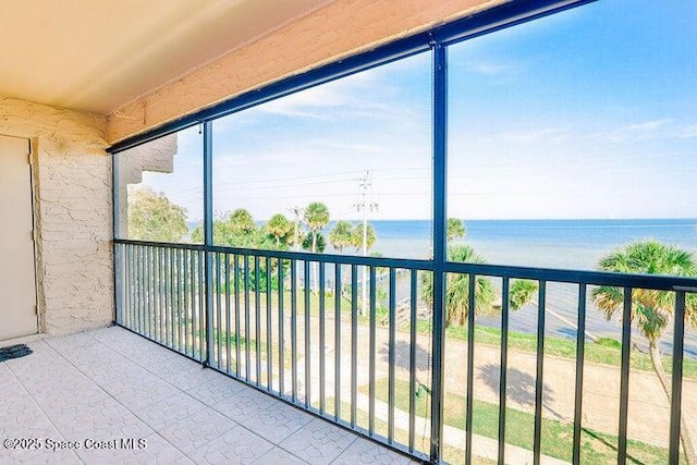 unfurnished sunroom featuring a water view