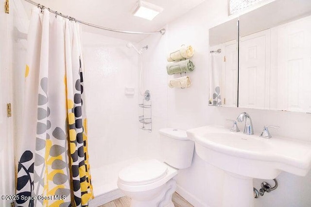 bathroom with toilet and a shower with shower curtain