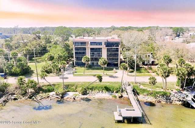 aerial view at dusk featuring a water view