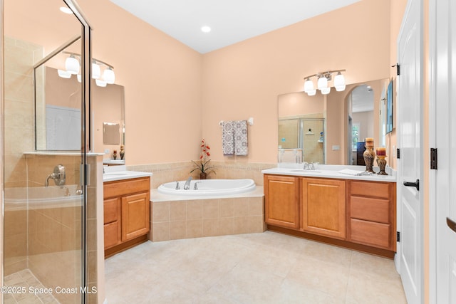 full bathroom featuring a sink, a shower stall, tile patterned floors, two vanities, and a garden tub