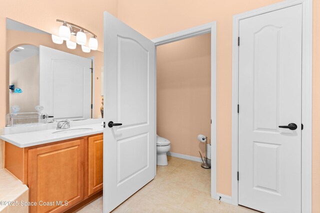 full bathroom with vanity, toilet, tile patterned flooring, and baseboards