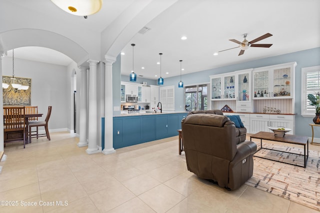 living room with recessed lighting, arched walkways, decorative columns, ceiling fan with notable chandelier, and visible vents