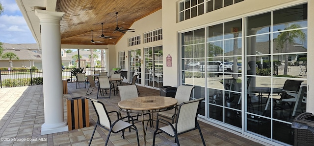 sunroom / solarium featuring outdoor dining area and a ceiling fan
