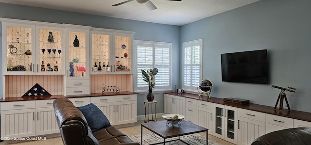 living area featuring a dry bar and ceiling fan