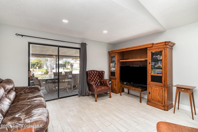 living room with light wood-type flooring, recessed lighting, and a textured ceiling