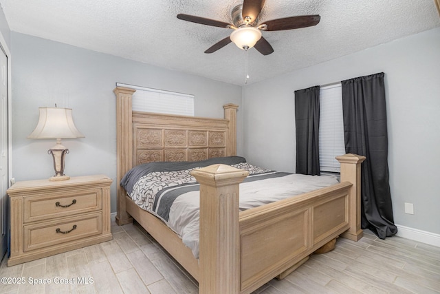 bedroom with light wood-style flooring, baseboards, a textured ceiling, and ceiling fan