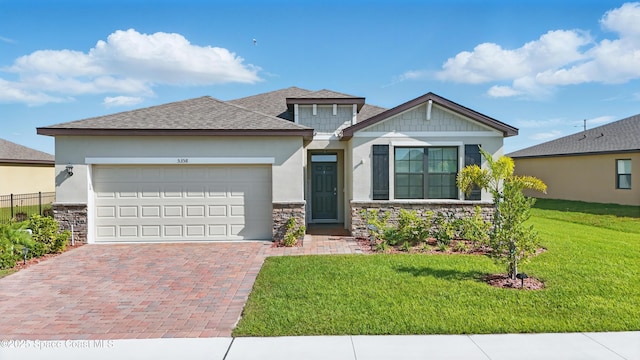 5358 Waterfall Pl, Grant, FL 32949 - view of front of home with stone siding, decorative driveway, stucco siding, an attached garage, and a front lawn