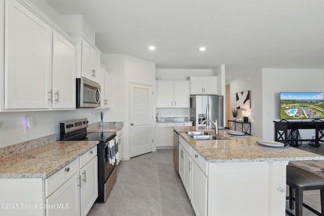 5358 Waterfall Pl, Grant, FL 32949 - kitchen featuring stainless steel appliances, a sink, a center island with sink, a kitchen bar, and white cabinets