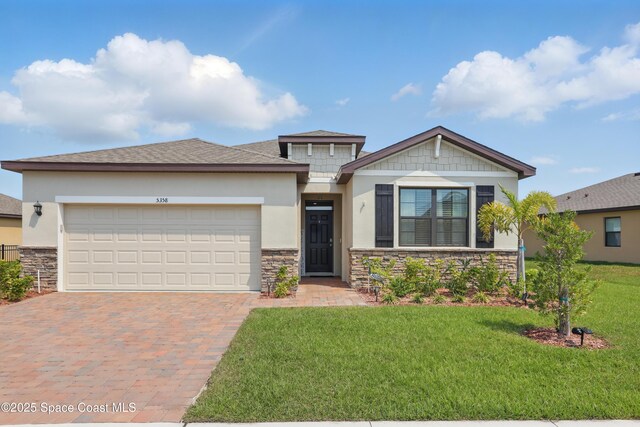 5358 Waterfall Pl, Grant, FL 32949 - view of front of house featuring stone siding, decorative driveway, a front lawn, a garage, and stucco siding