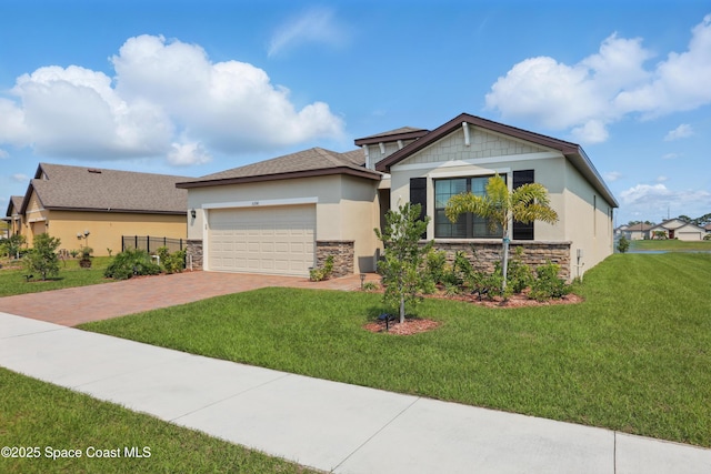 5358 Waterfall Pl, Grant, FL 32949 - view of front of property with stone siding, stucco siding, decorative driveway, a garage, and a front yard