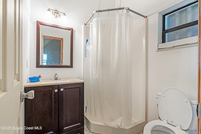 bathroom featuring toilet, vanity, and a shower with shower curtain