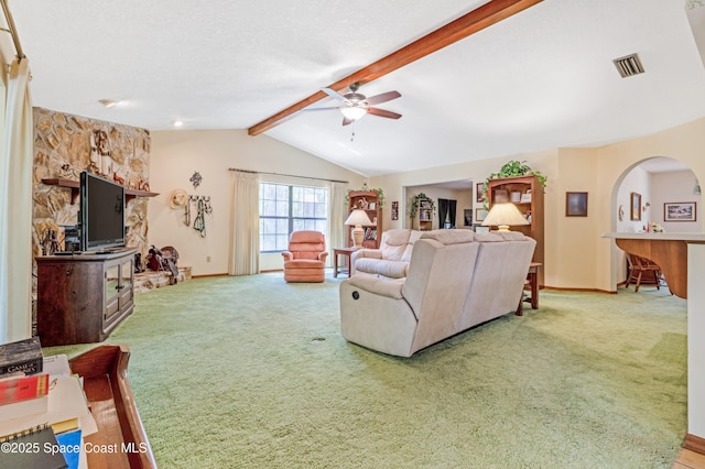 carpeted living area featuring lofted ceiling with beams, ceiling fan, baseboards, and visible vents