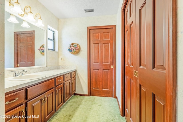 bathroom with a textured ceiling, visible vents, and vanity