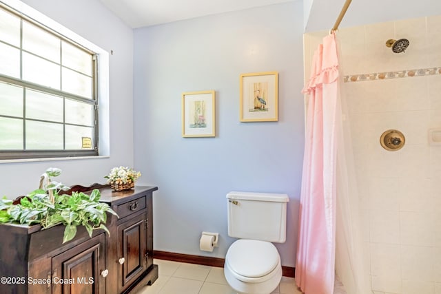 bathroom featuring baseboards, a tile shower, toilet, and tile patterned flooring