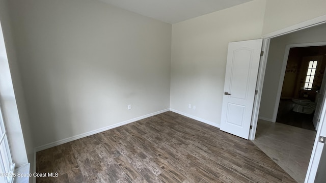 466 Stonehenge Cir, Rockledge, FL 32955 - empty room with baseboards and dark wood-type flooring