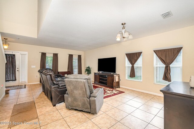 living area featuring light tile patterned floors, baseboards, a notable chandelier, and visible vents