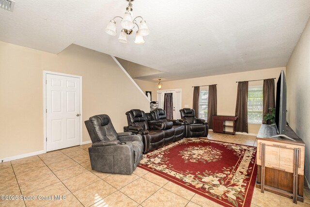 living room with visible vents, baseboards, light tile patterned floors, and a chandelier