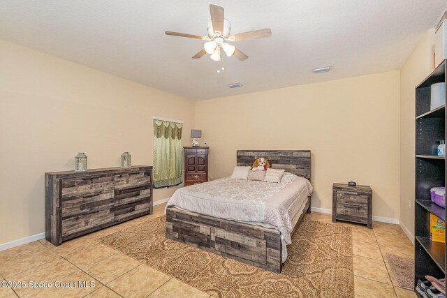bedroom featuring light tile patterned floors, baseboards, ceiling fan, and visible vents