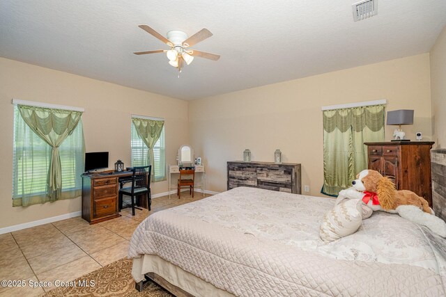 bedroom featuring ceiling fan, baseboards, visible vents, and light tile patterned floors