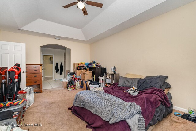 bedroom with a raised ceiling, arched walkways, carpet, baseboards, and visible vents