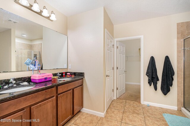 full bathroom featuring double vanity, visible vents, a shower stall, and a sink
