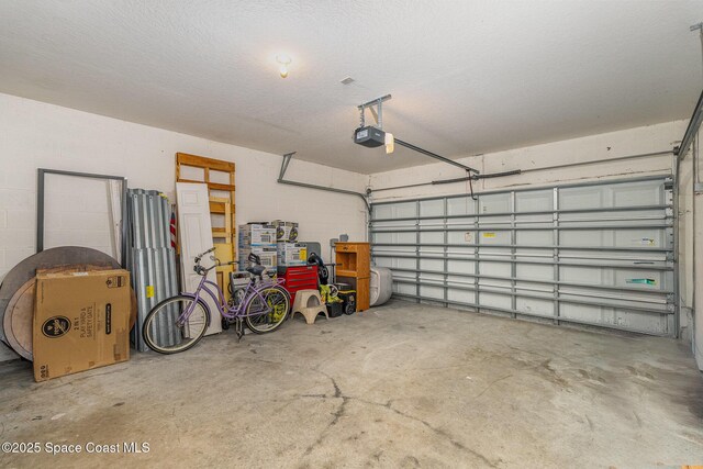 garage with concrete block wall and a garage door opener