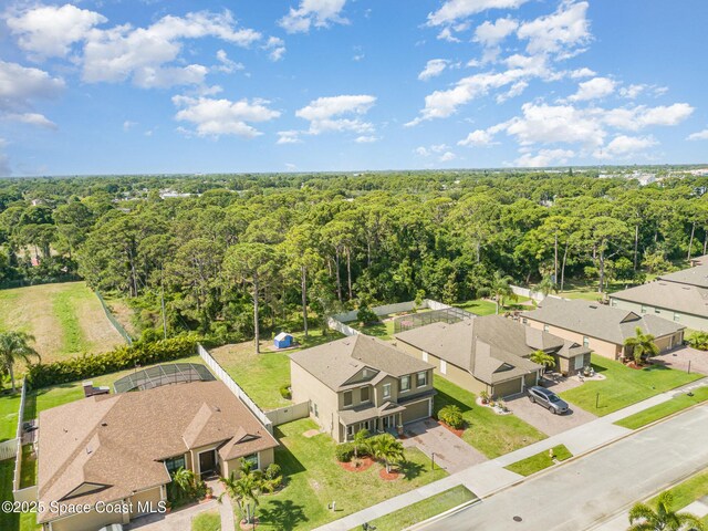 drone / aerial view featuring a residential view and a forest view