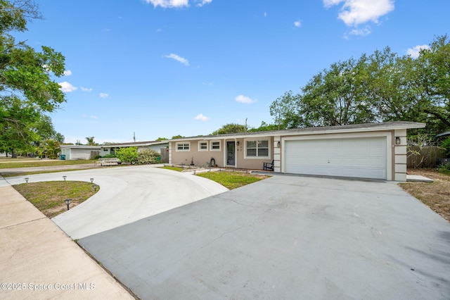 ranch-style house featuring an attached garage, driveway, and stucco siding
