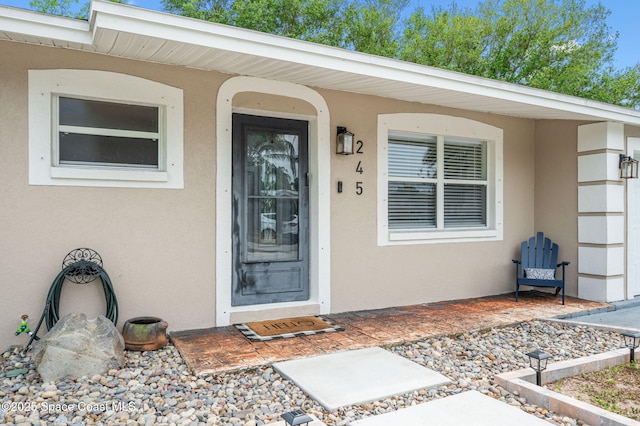 view of exterior entry with stucco siding