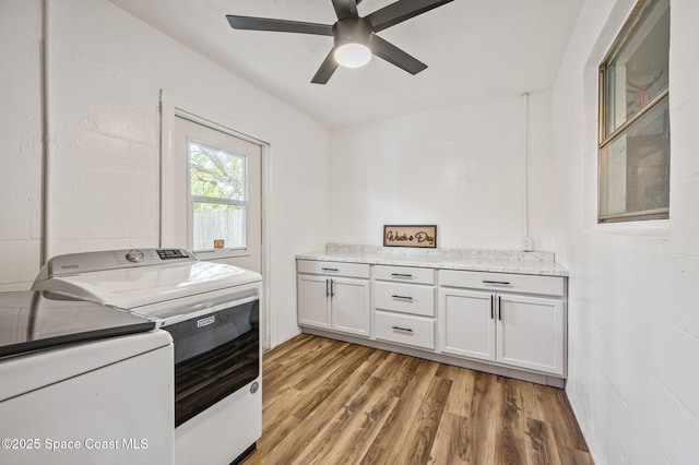laundry area featuring cabinet space, independent washer and dryer, a ceiling fan, and light wood finished floors