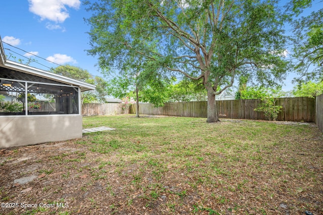 view of yard featuring a fenced backyard and a sunroom
