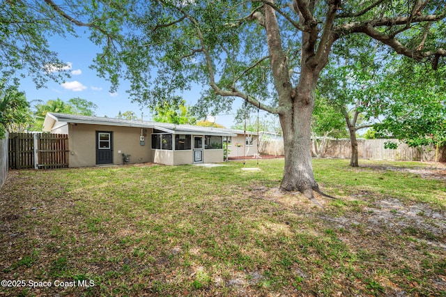 view of yard featuring a fenced backyard and a sunroom