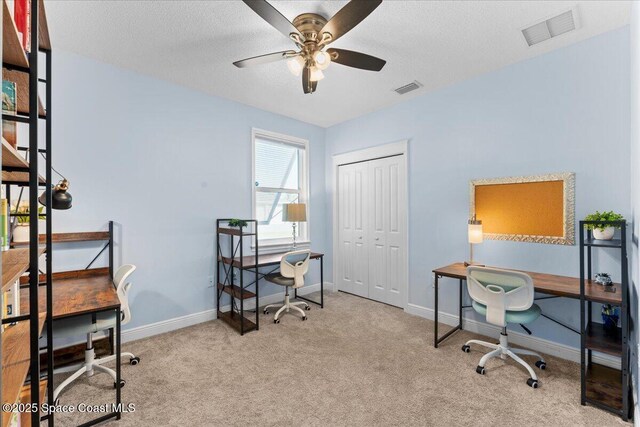 home office featuring a ceiling fan, visible vents, and carpet