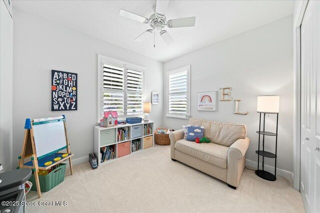 interior space with baseboards, carpet floors, and ceiling fan