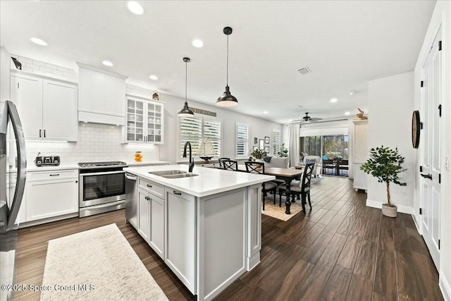 kitchen with a sink, light countertops, backsplash, appliances with stainless steel finishes, and recessed lighting